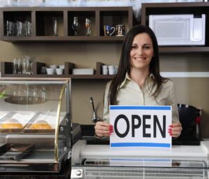 Happy Owner Of A Caf Showing Open Sign